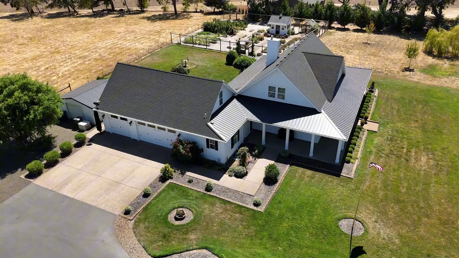Aerial view of the white farmhouse, driveway and lawn