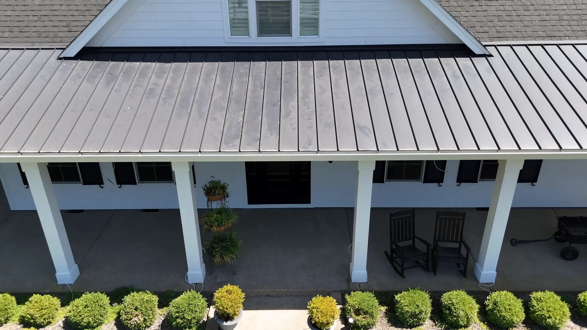 Wraparound porch with white columns and rocking chairs