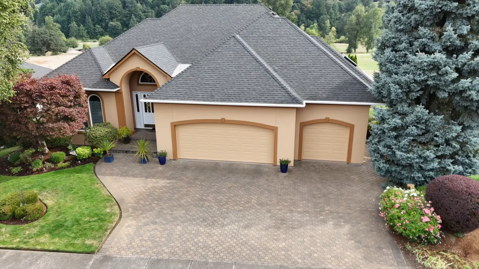 Front of the home after painting, warm sand body with bronze garage trim