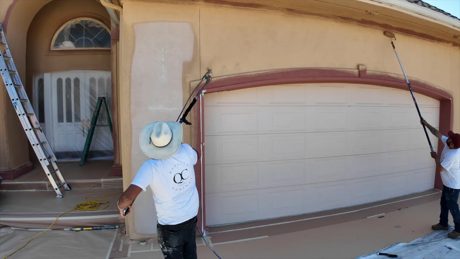 QC painter back-rolling fresh paint on the garage wall