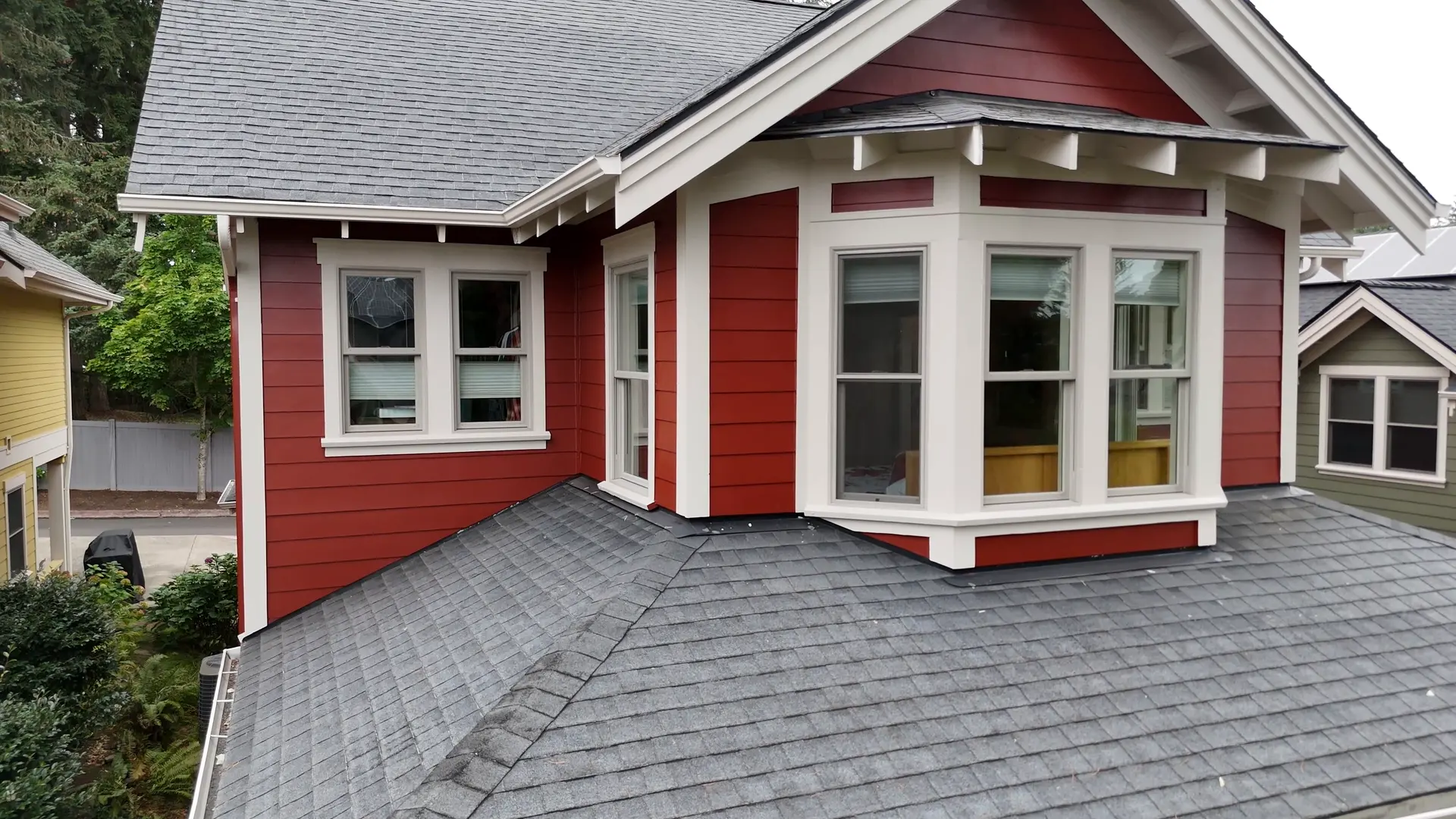 Craftsman bay window after painting, deep red siding with white trim