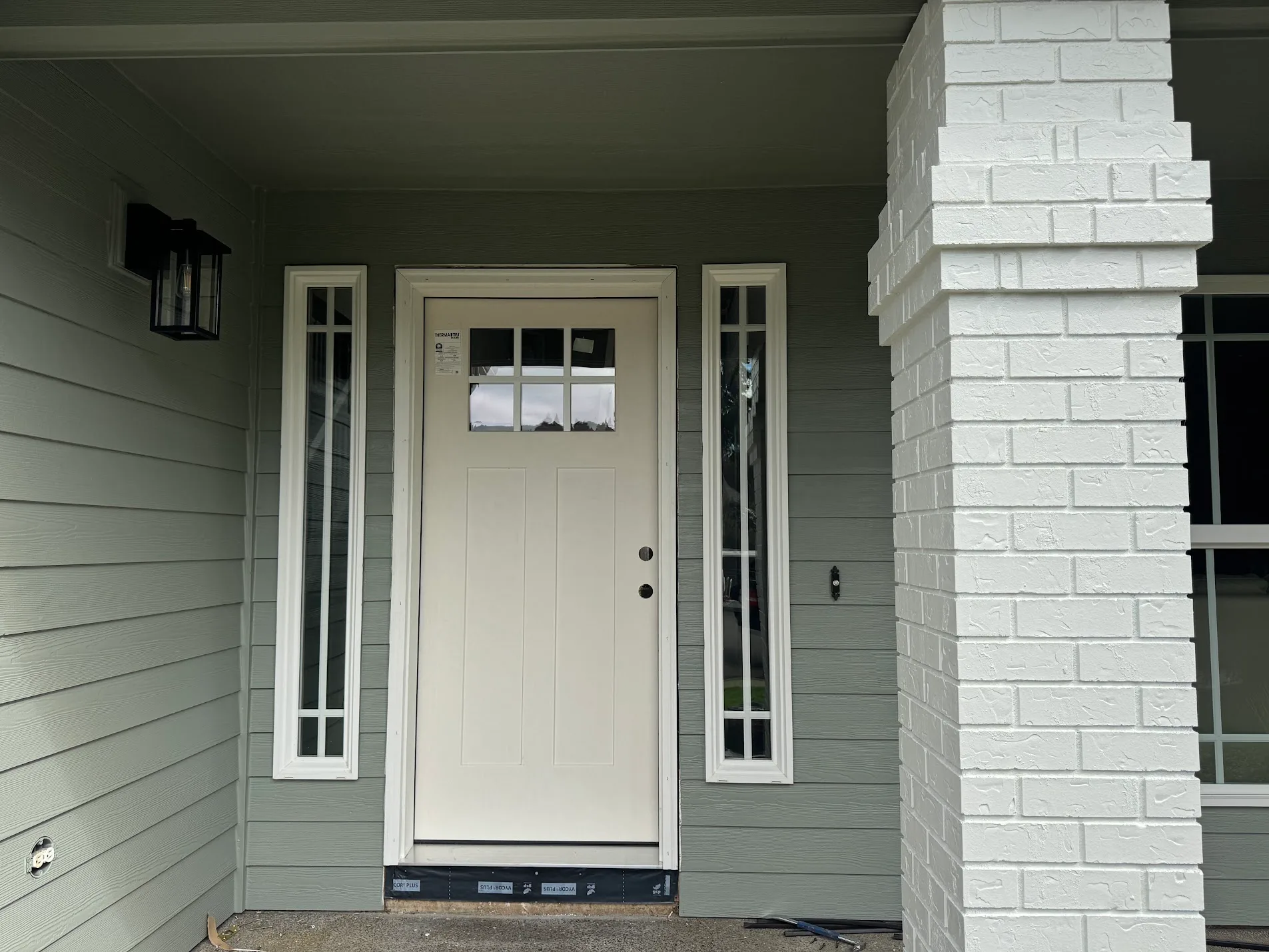 Craftsman front door in original white factory primer with sidelights before painting