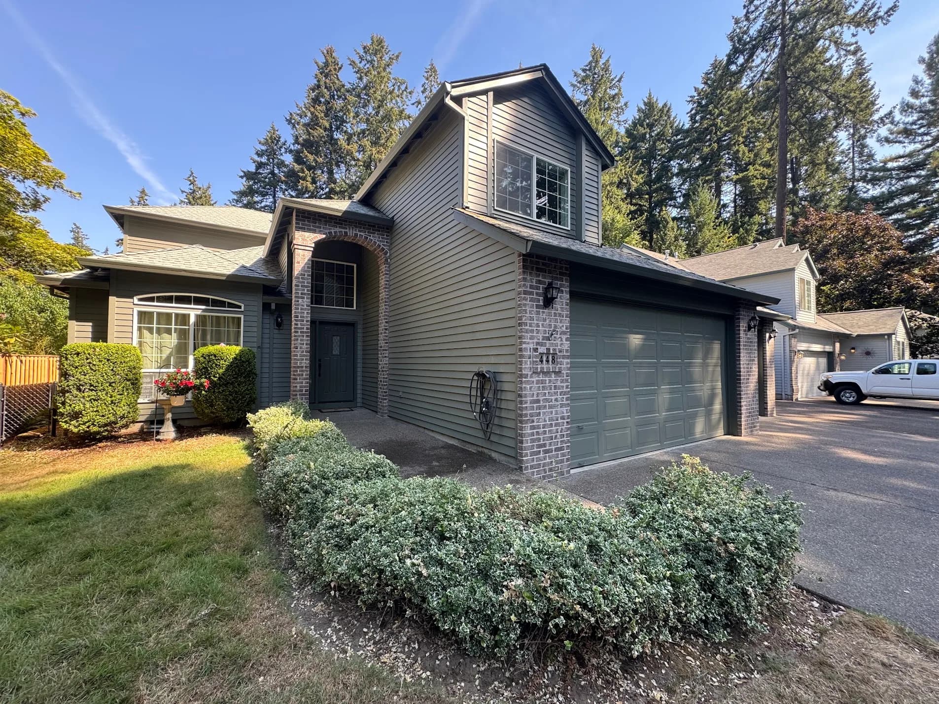 Freshly painted sage green lap siding and dark trim on a two-story Willamette Valley home