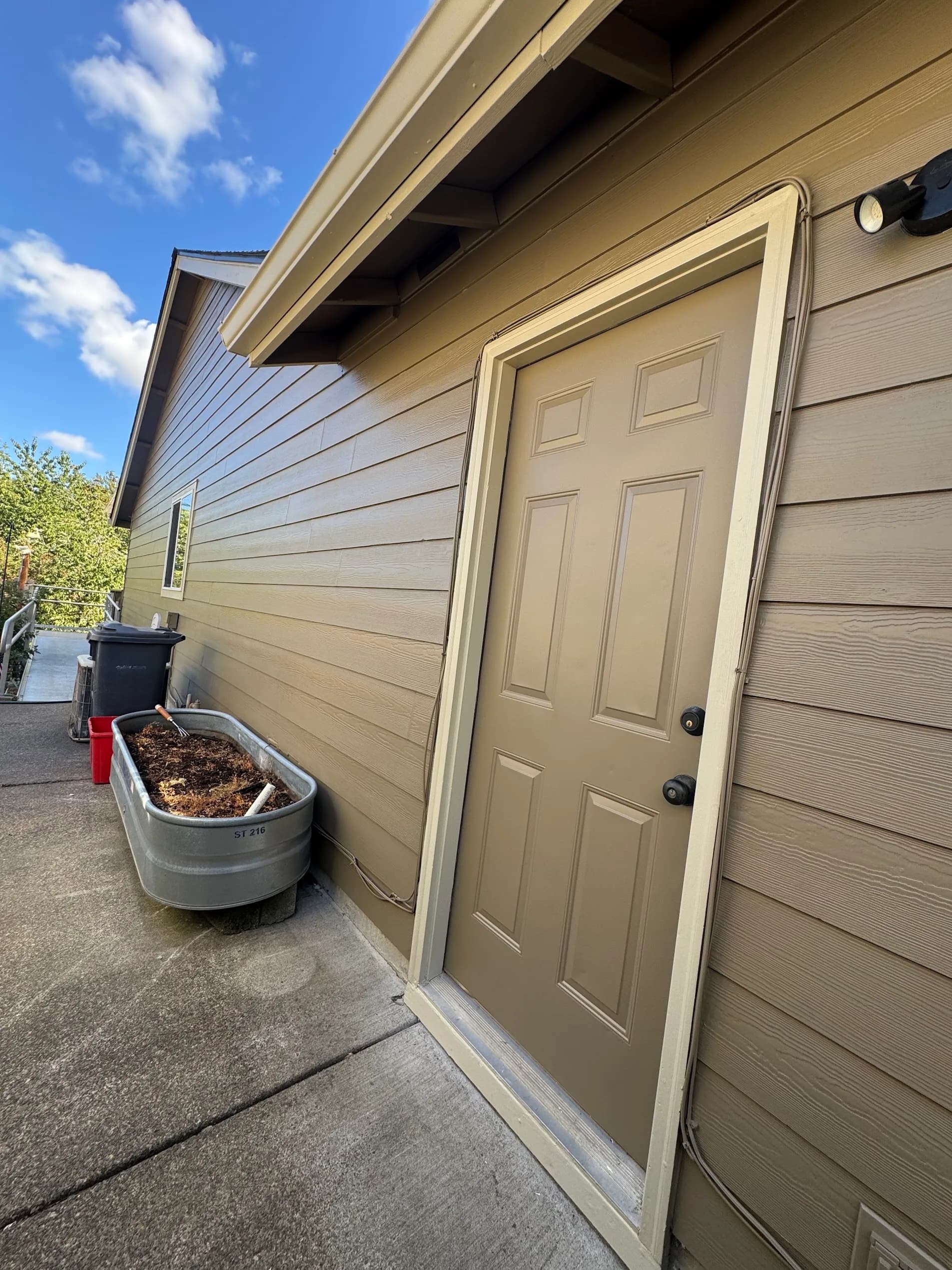 Tan painted lap siding and matching exterior door on a single-story Oregon home