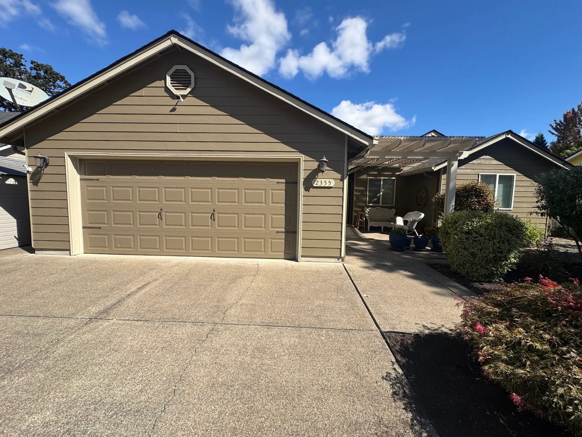 Tan ranch home with repainted garage door, pergola and trim in the Willamette Valley