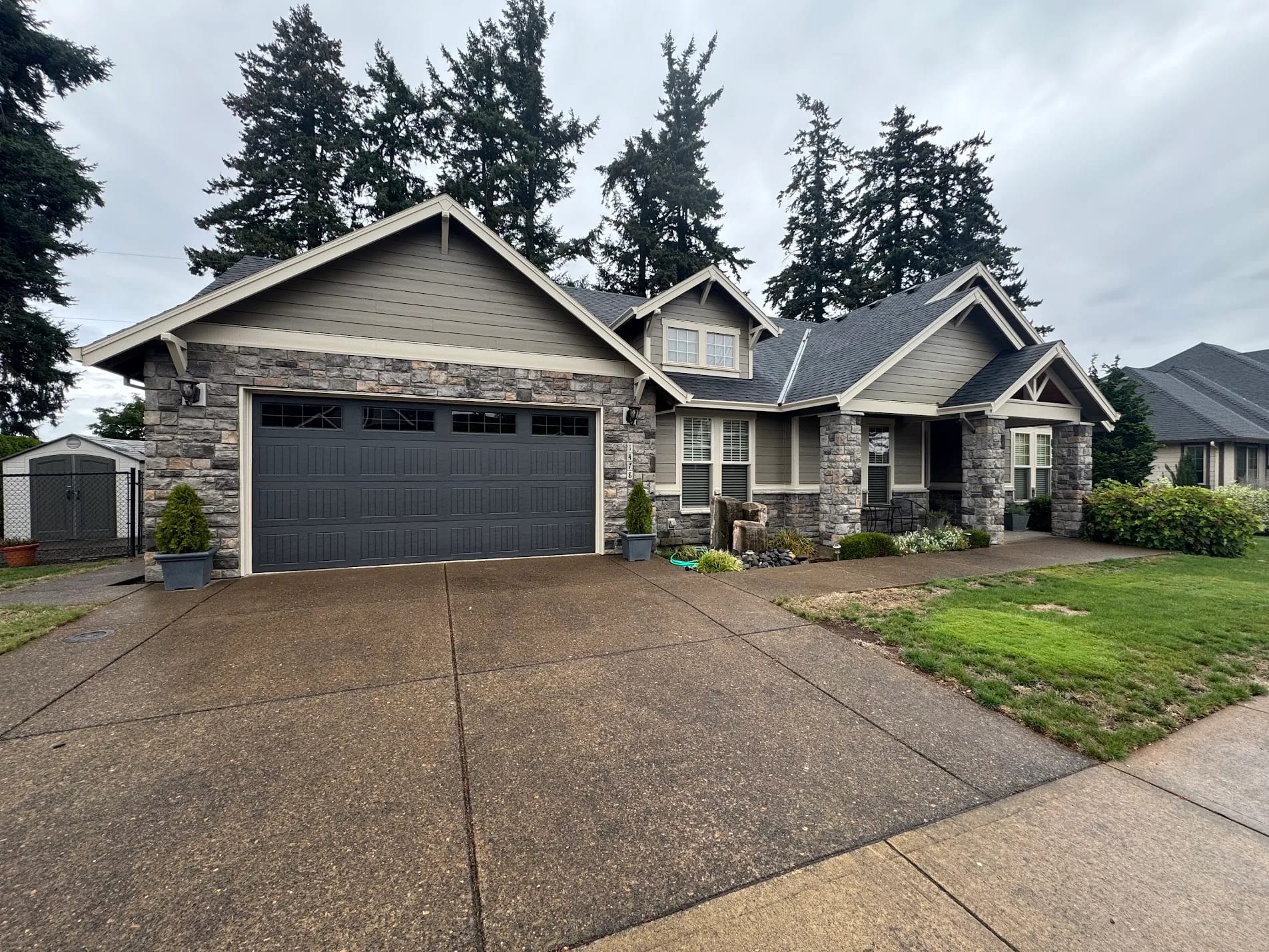 Full front elevation of a craftsman home after exterior repaint in gray with stone accents